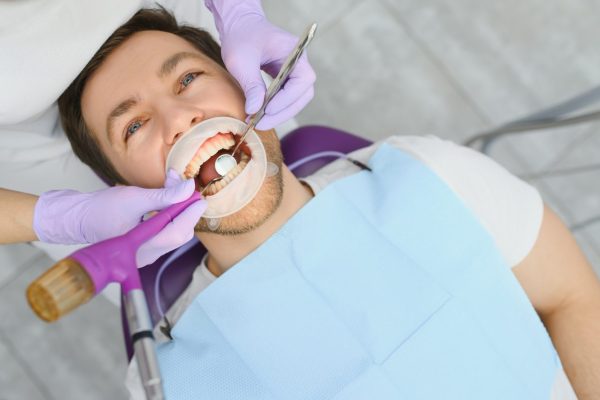 periodontal-services-closeup-shot-of-smiling-man-getting-treatment-in-stomatologic-clinic.jpg